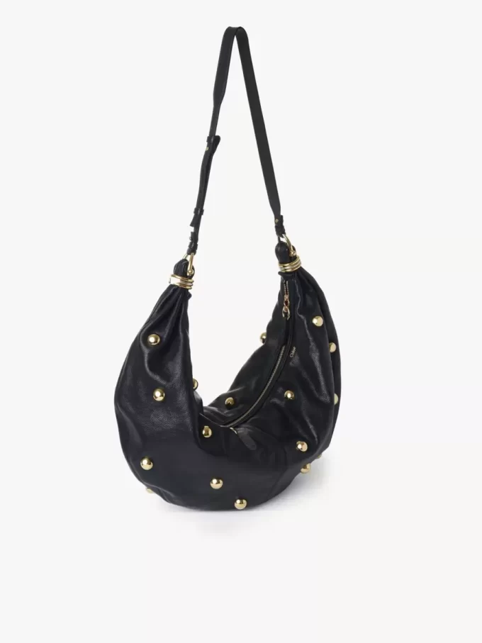 Große Hobo-Tasche „Armband“ aus genarbtem Leder mit Nieten Große Hobo-Tasche „Armband“ aus genarbtem Leder mit Nieten