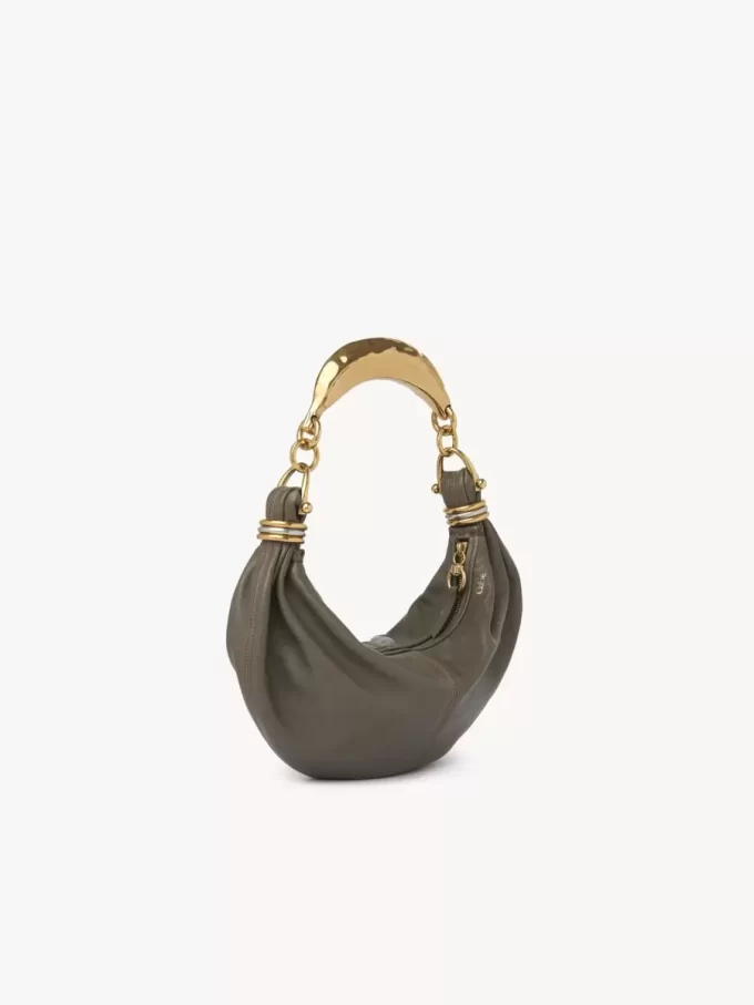 Kleine Hobo-Tasche mit Armband aus genarbtem Leder Kleine Hobo-Tasche mit Armband aus genarbtem Leder