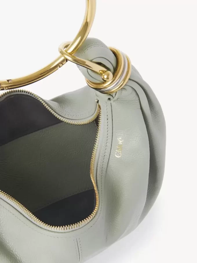 Kleine Hobo-Tasche mit Armband aus genarbtem Leder Kleine Hobo-Tasche mit Armband aus genarbtem Leder