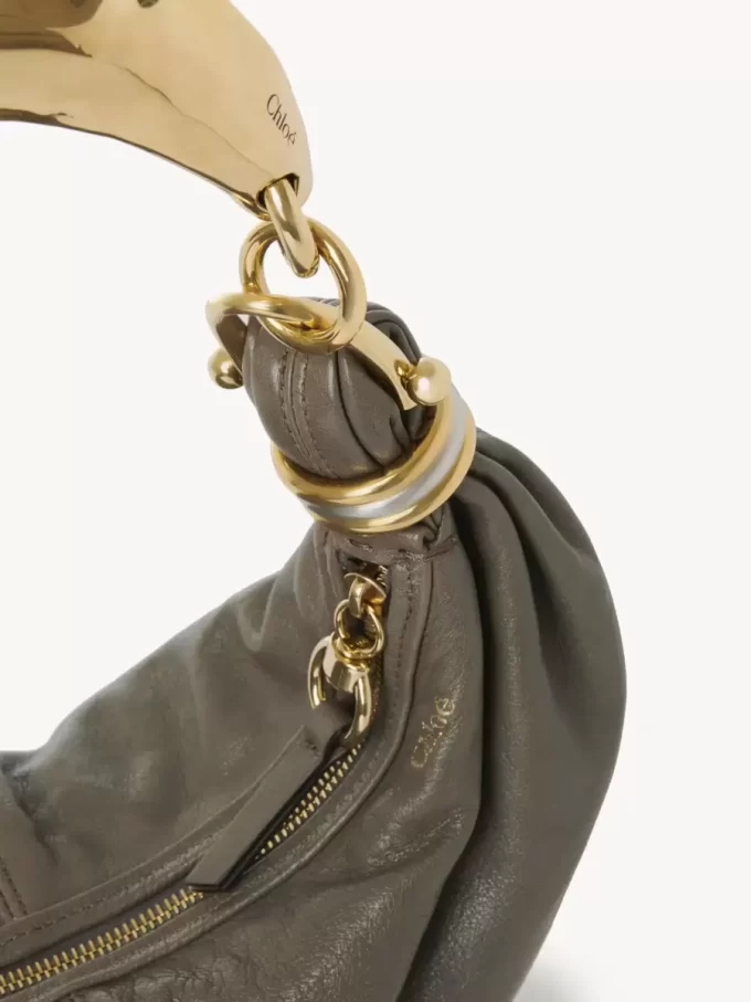 Kleine Hobo-Tasche mit Armband aus genarbtem Leder Kleine Hobo-Tasche mit Armband aus genarbtem Leder