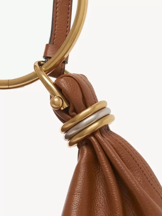 Kleine Hobo-Tasche mit Armband aus genarbtem Leder Kleine Hobo-Tasche mit Armband aus genarbtem Leder