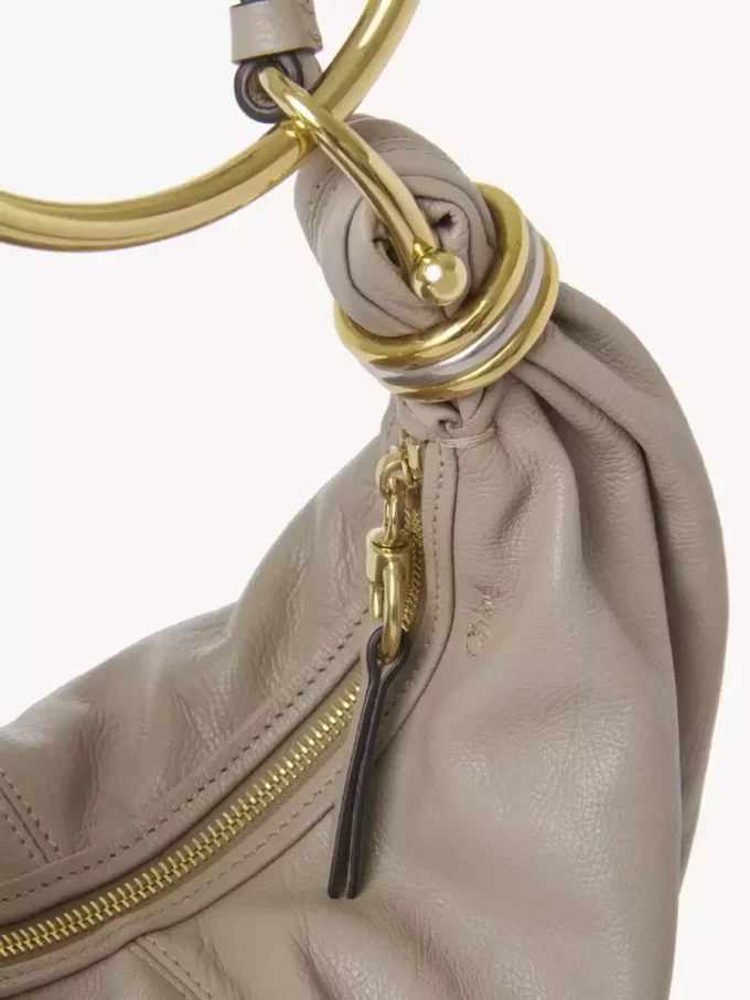 Kleine Hobo-Tasche mit Armband aus genarbtem Leder Kleine Hobo-Tasche mit Armband aus genarbtem Leder