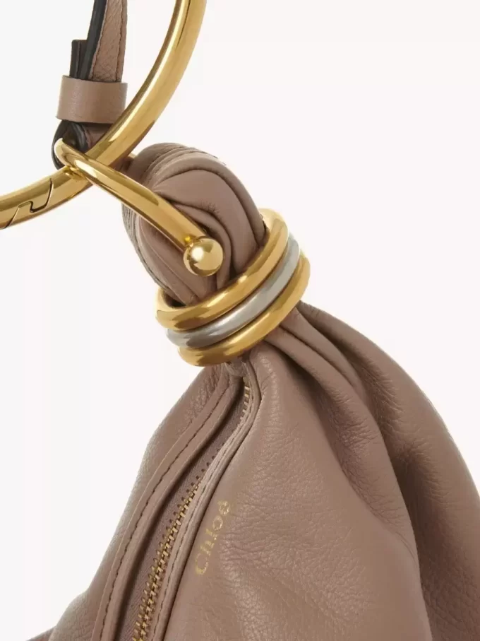 Kleine Hobo-Tasche mit Armband aus genarbtem Leder Kleine Hobo-Tasche mit Armband aus genarbtem Leder