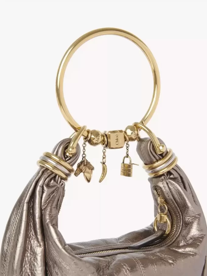 Kleine Hobo-Tasche mit Armband aus metallisiertem Leder Kleine Hobo-Tasche mit Armband aus metallisiertem Leder